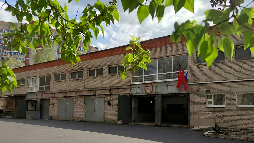 Фасад гаража под листвой
